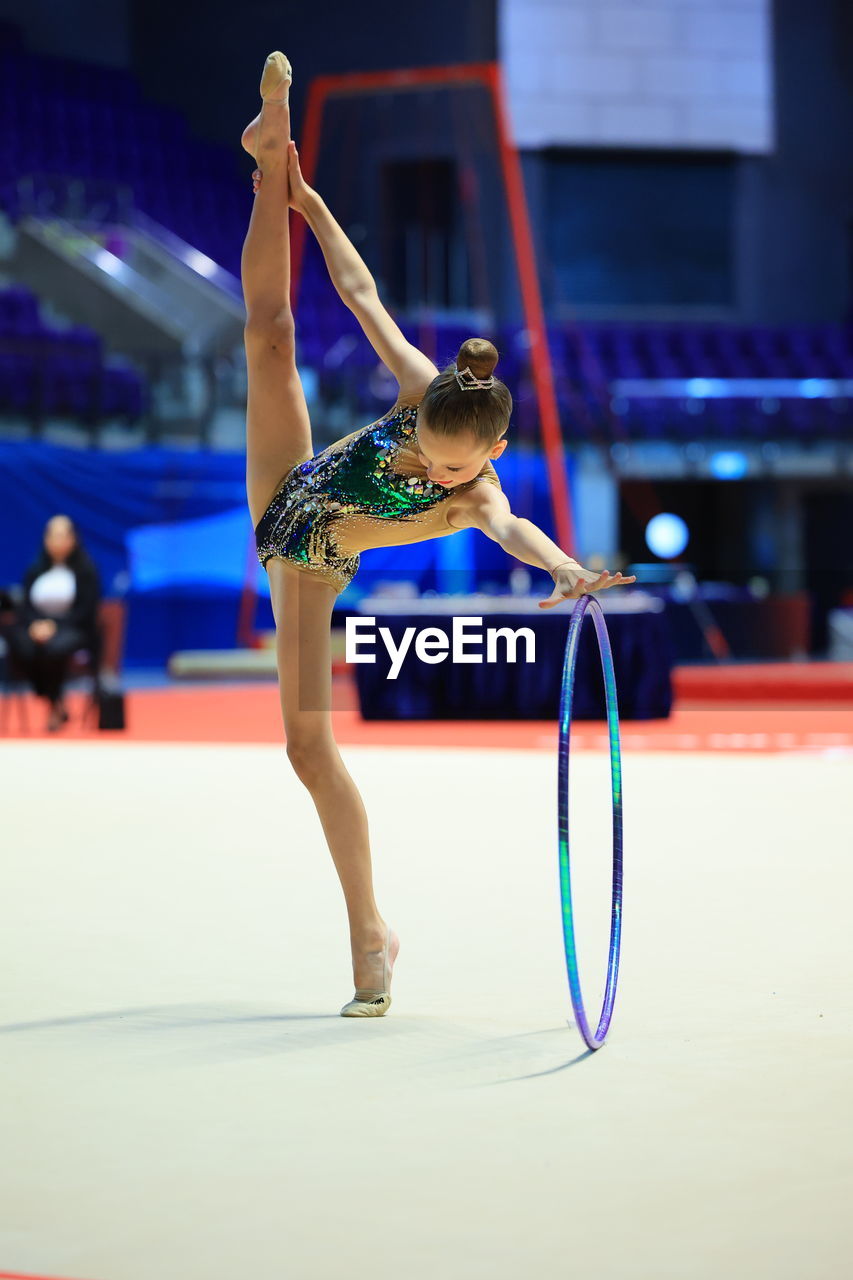 Rhythmic gymnastics in the professional arena. performance with the hoop in front of the audience