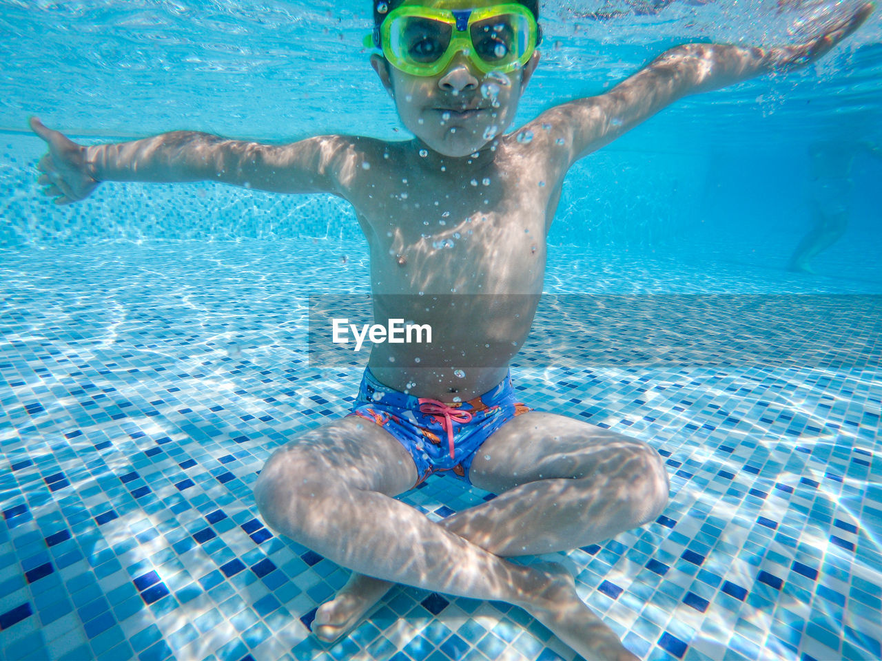 Portrait of boy sitting in swimming pool