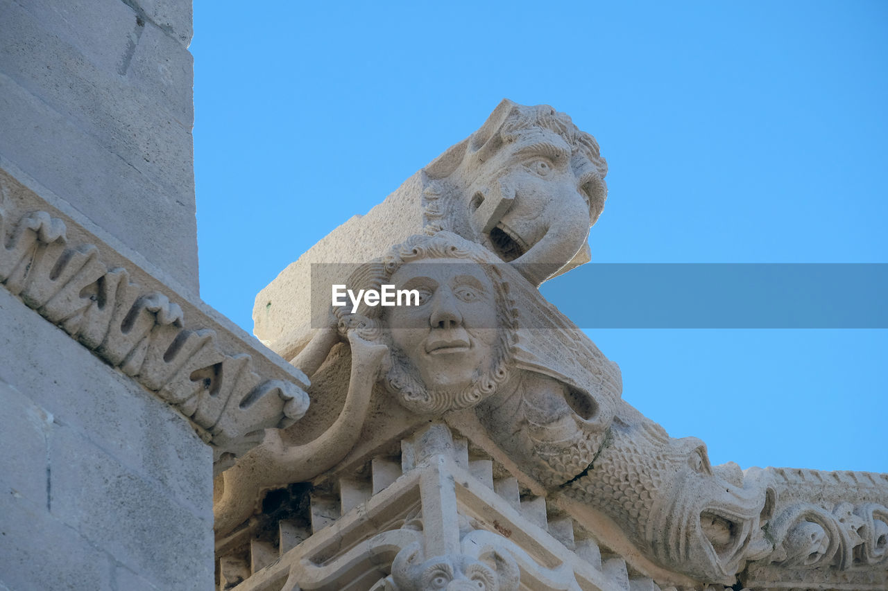 LOW ANGLE VIEW OF STATUE AGAINST HISTORIC BUILDING