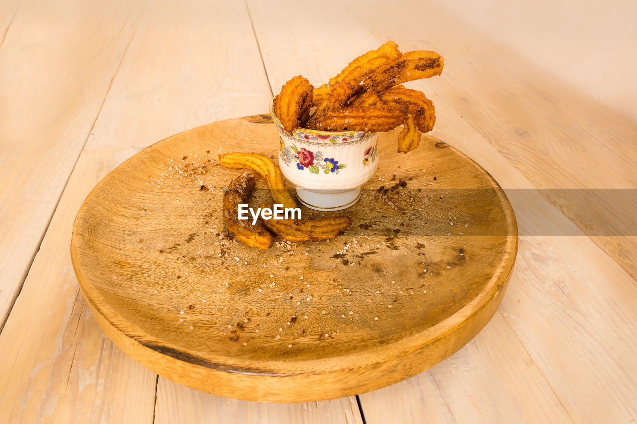 Churros on cutting board over table