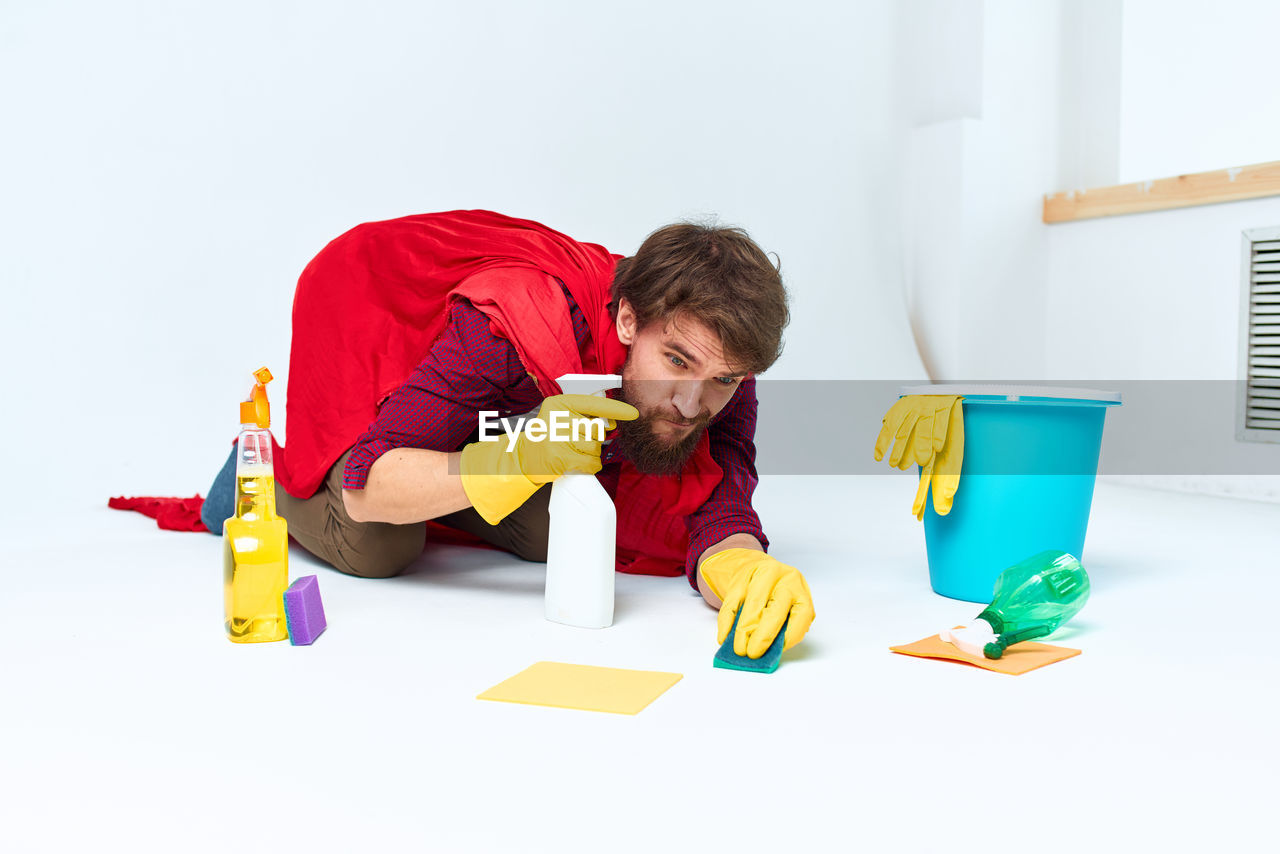 rear view of boy playing with toy blocks against white background