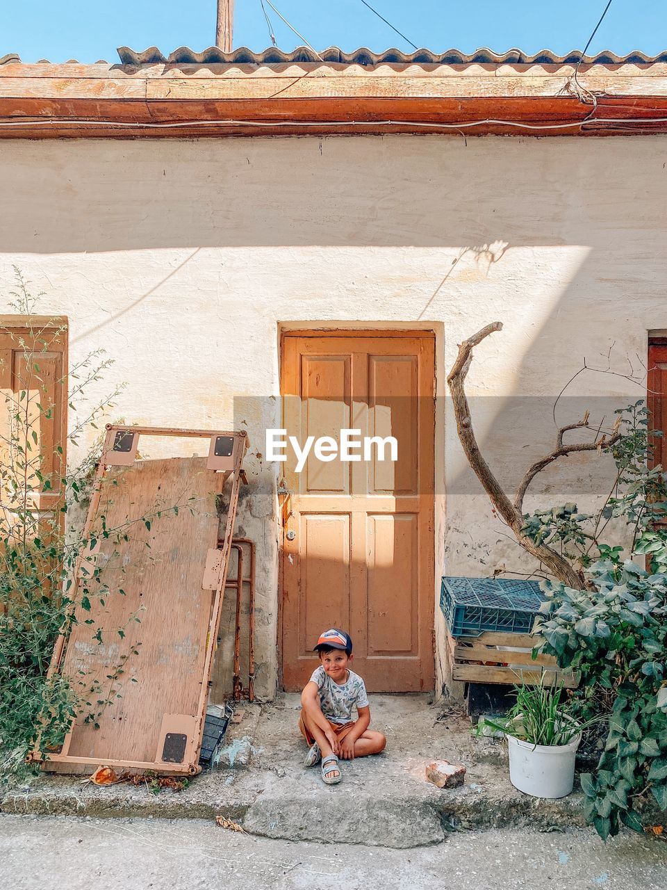 MAN SITTING OUTSIDE OF HOUSE