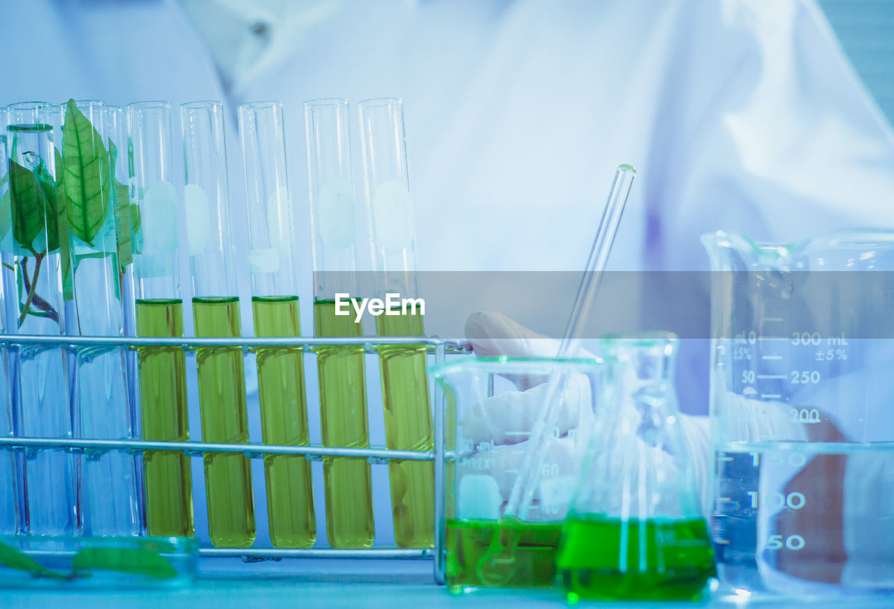 Midsection of scientist examining chemical in laboratory