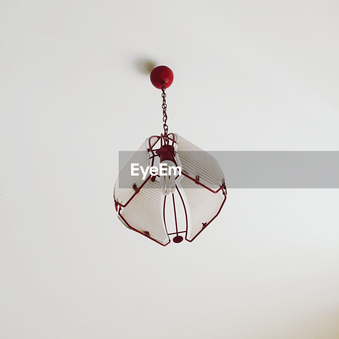 Modern lamp hanging from white ceiling