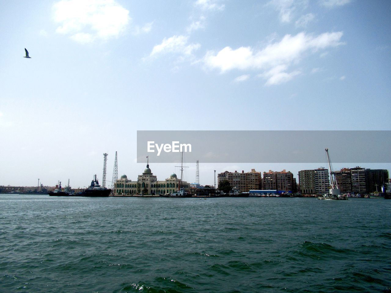 SEA BY BUILDINGS AGAINST SKY