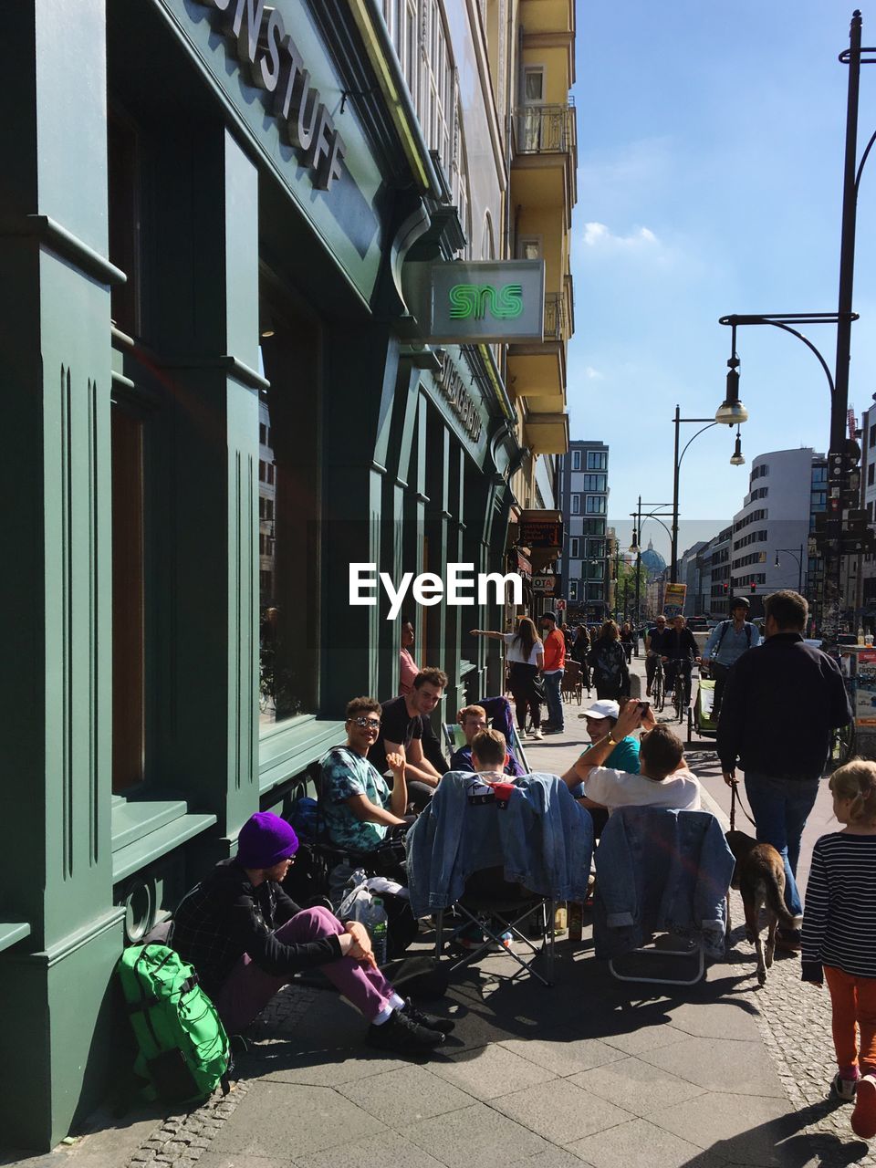 CROWD ON STREET IN CITY AGAINST SKY