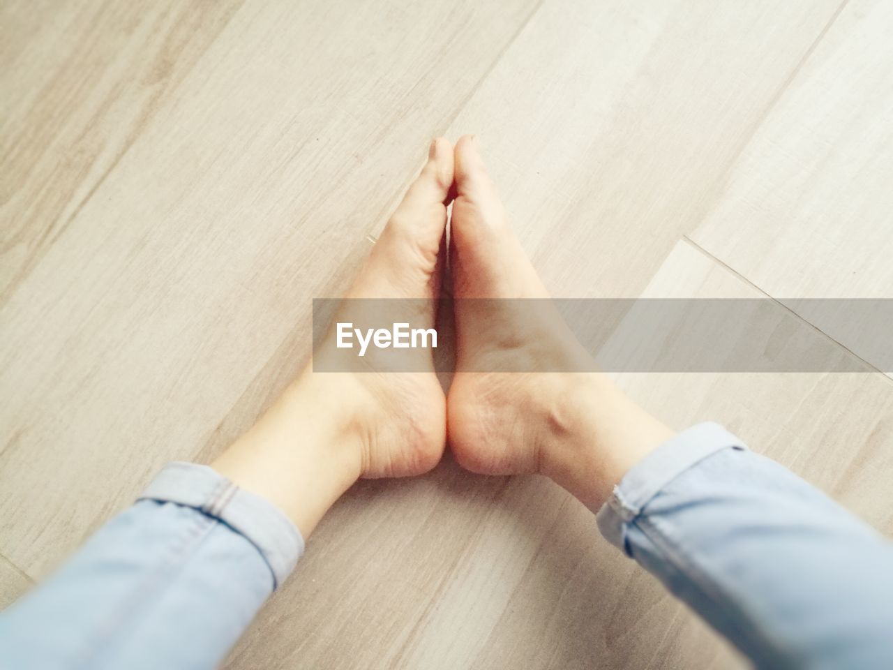 Low section of woman sitting on hardwood floor