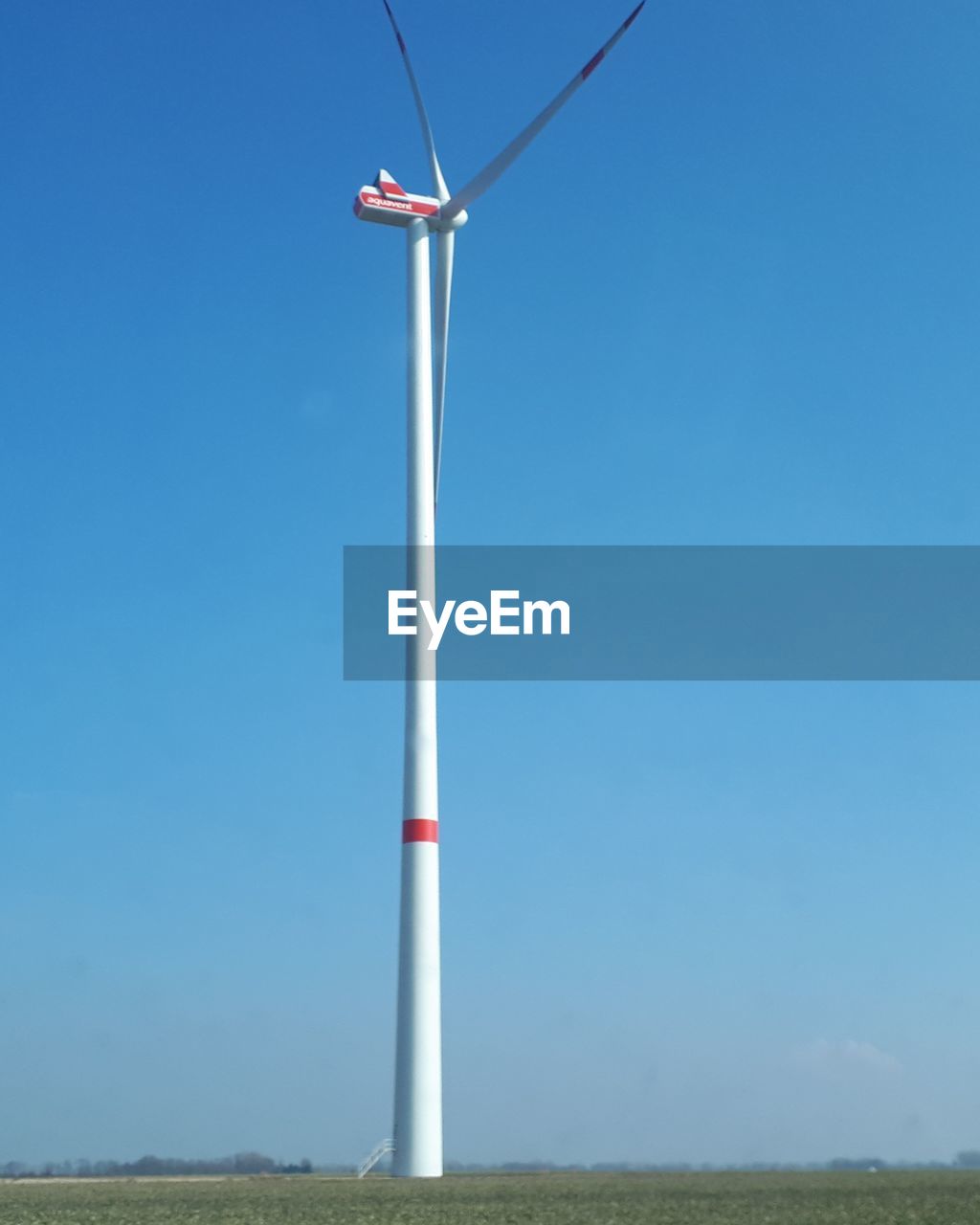 Low angle view of windmill against clear blue sky