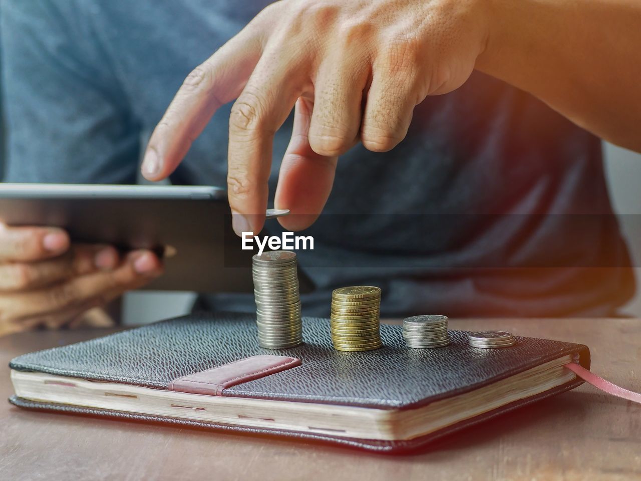 Close-up of hand holding coin on table