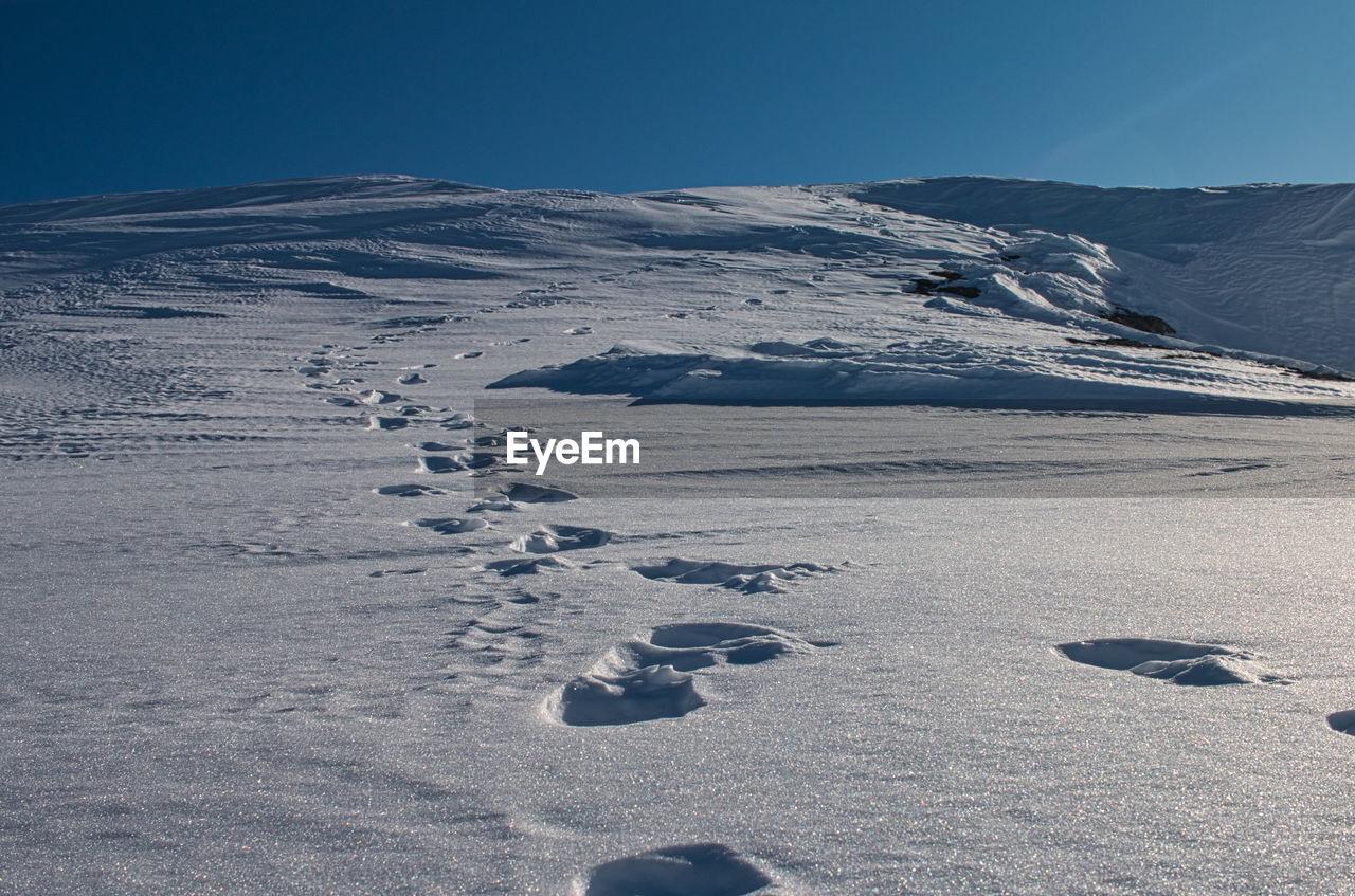 Scenic view of snowcapped mountains against clear sky