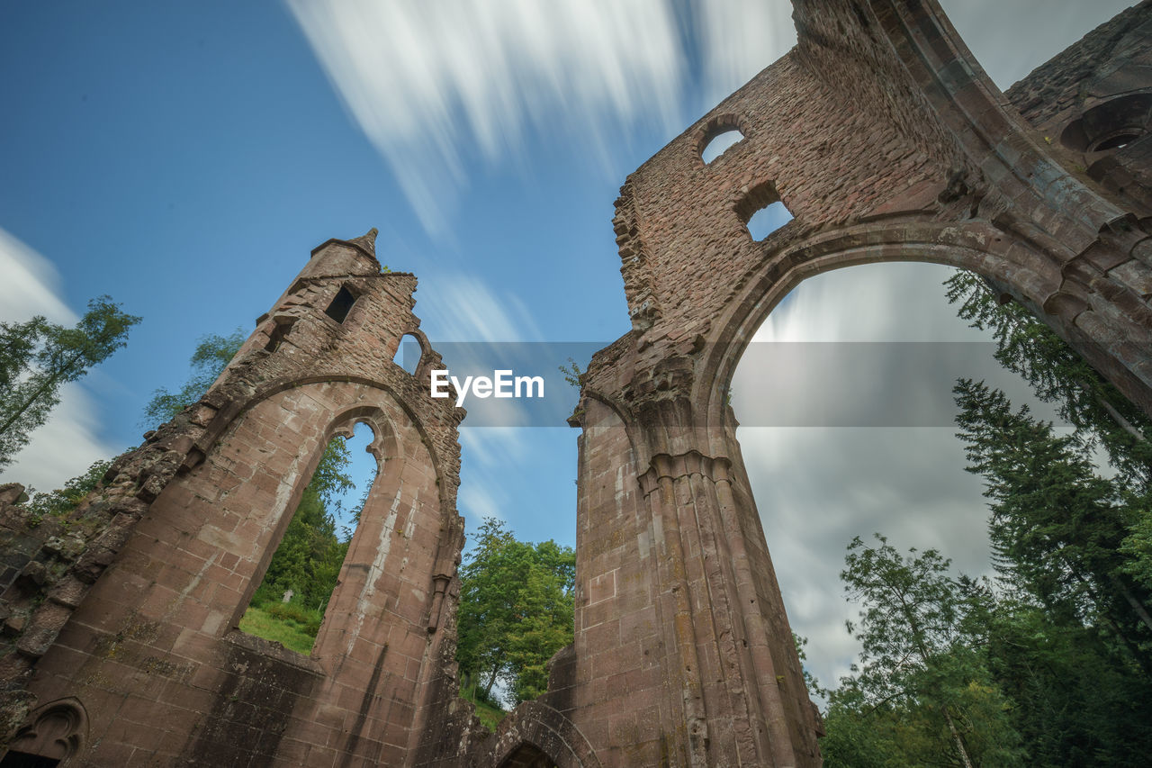 Low angle view of old built structures against cloudy sky