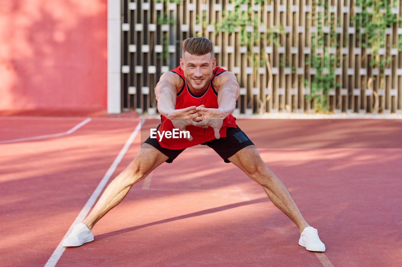 full length of woman exercising on court