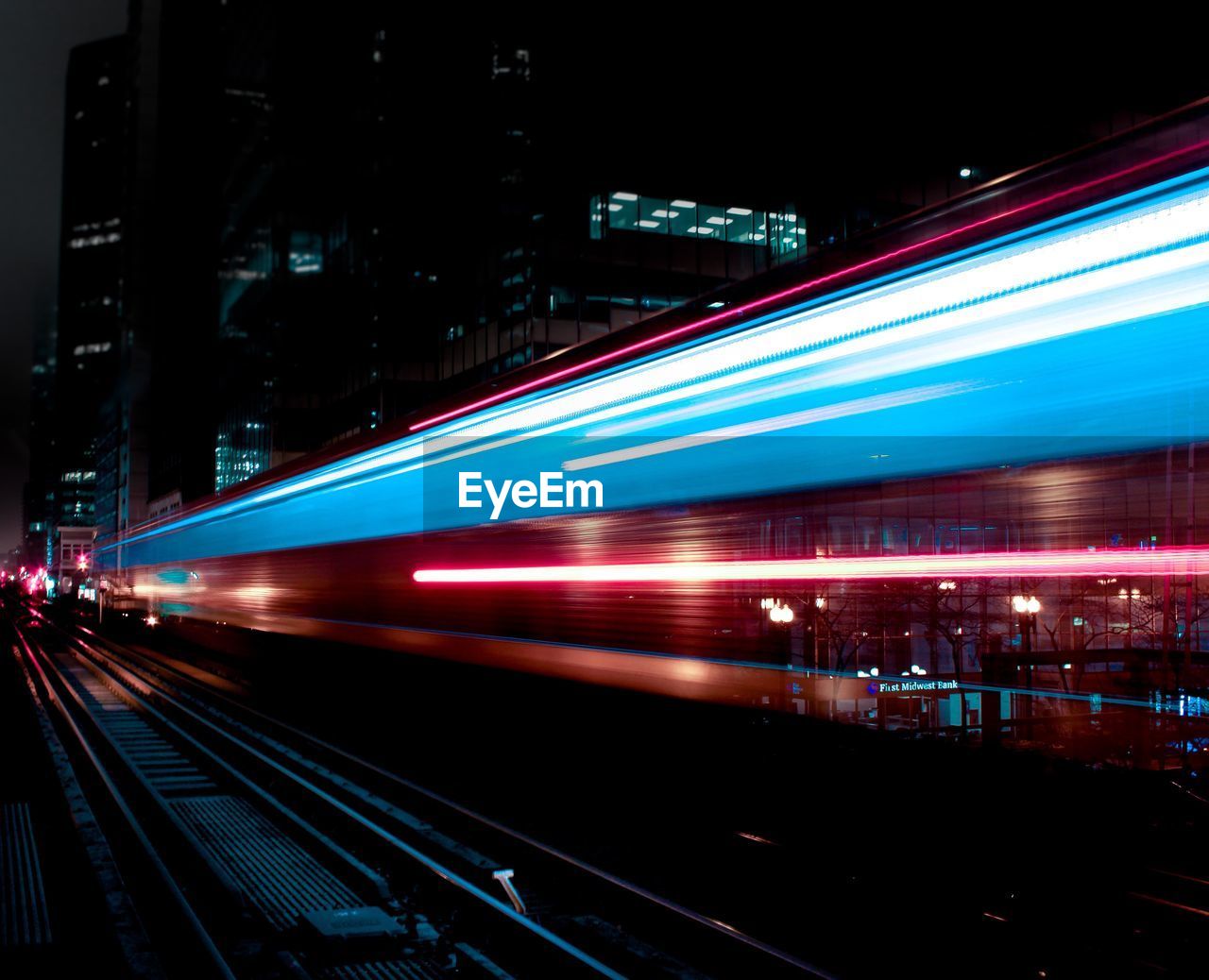 LIGHT TRAILS ON RAILROAD TRACK AT NIGHT