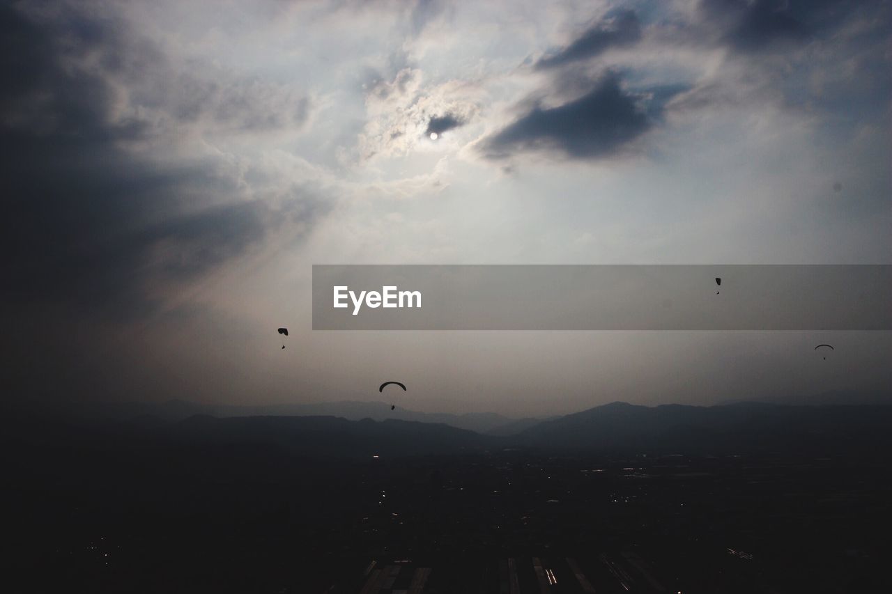 LOW ANGLE VIEW OF SILHOUETTE FLYING AGAINST SKY