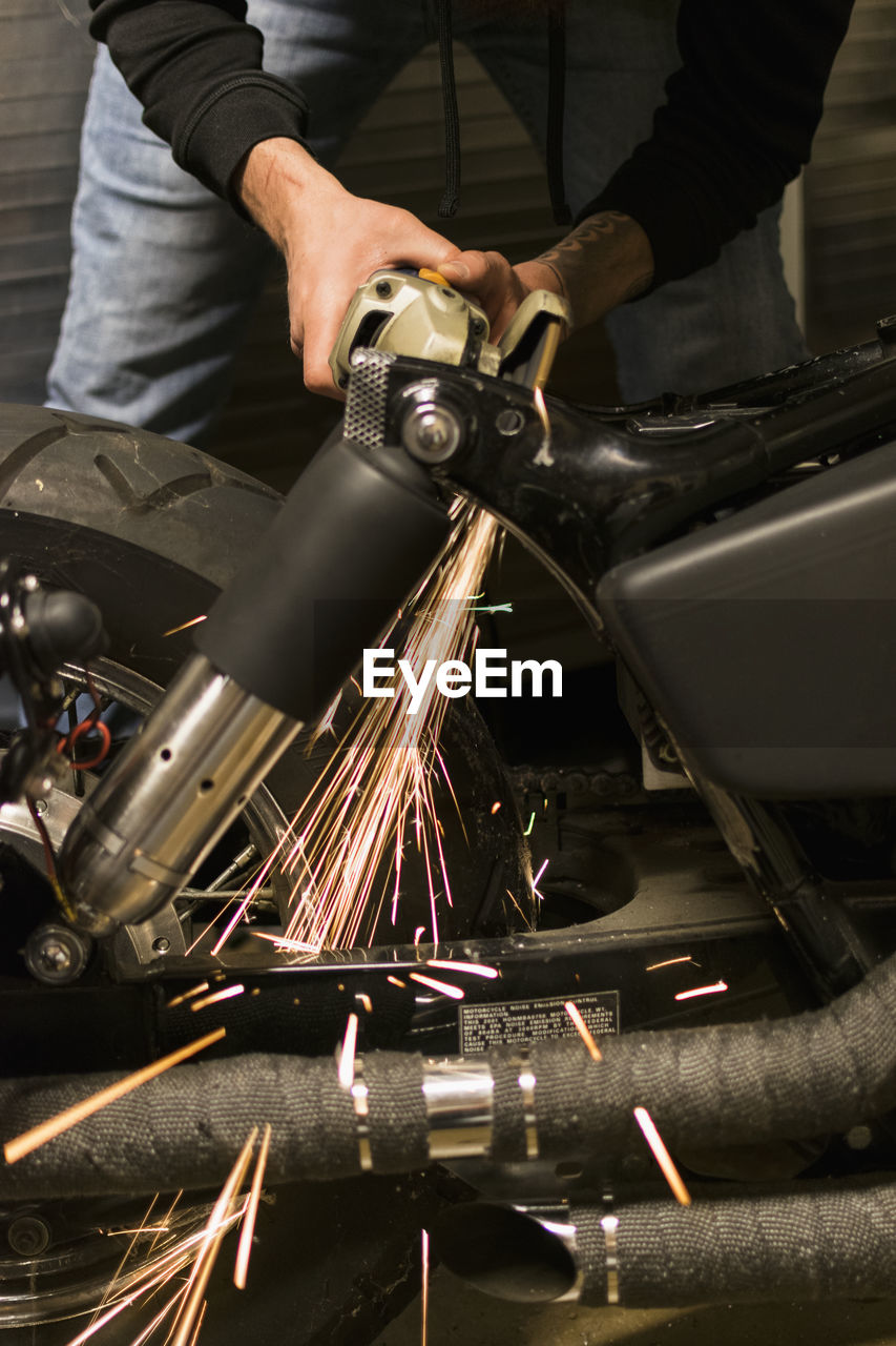 LOW ANGLE VIEW OF MAN WORKING ON METAL