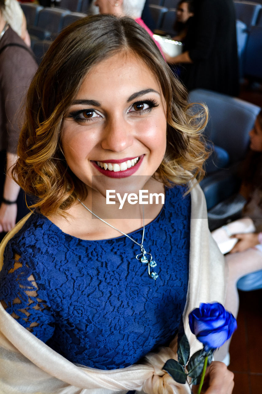 PORTRAIT OF A SMILING YOUNG WOMAN WITH BLUE EYES