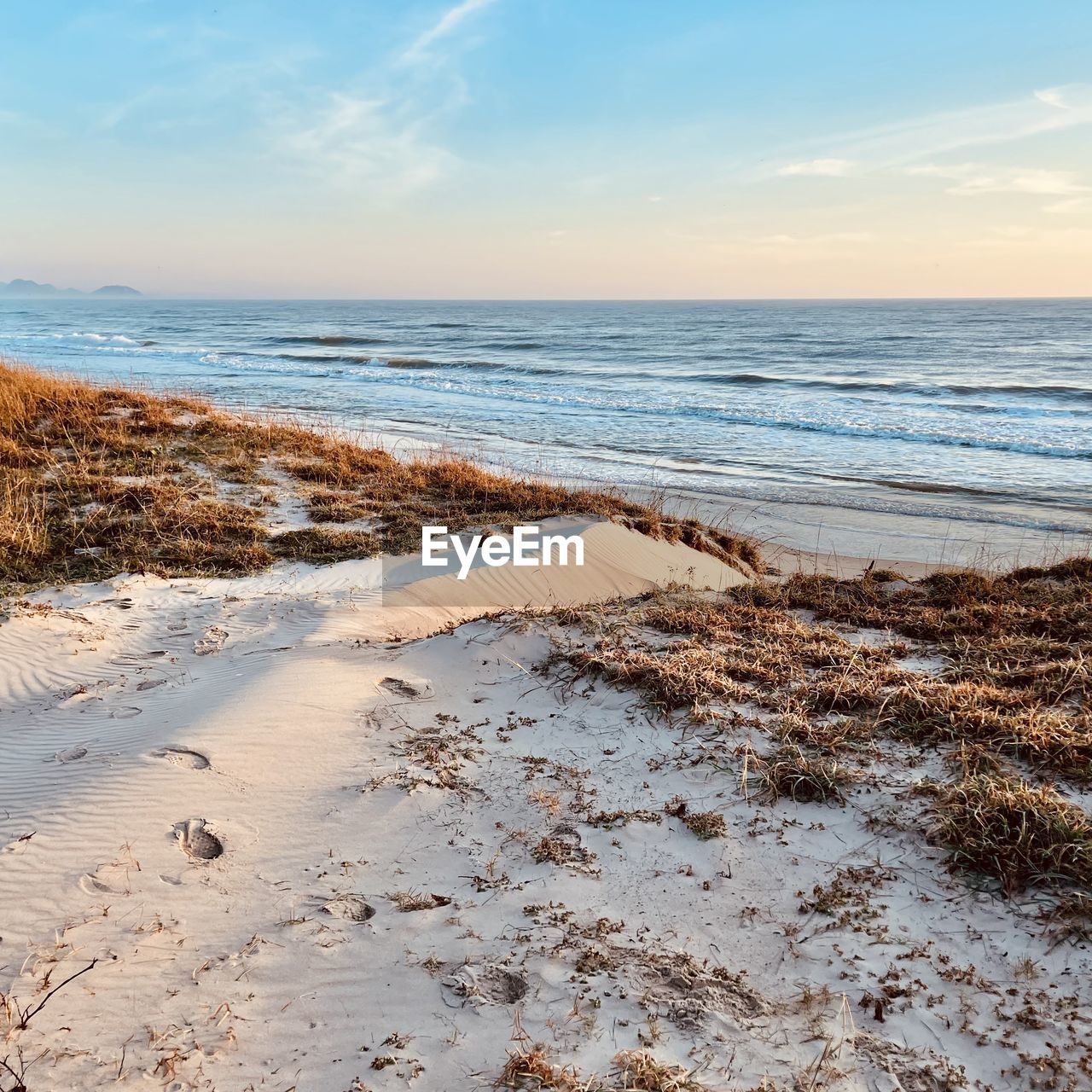 sea, land, beach, water, sky, shore, body of water, sand, wave, ocean, scenics - nature, beauty in nature, horizon over water, coast, nature, horizon, tranquility, tranquil scene, wind wave, cloud, sunset, rock, no people, natural environment, sunlight, environment, motion, idyllic, outdoors, winter, day, travel destinations, coastline, landscape, travel, water sports, non-urban scene, seascape