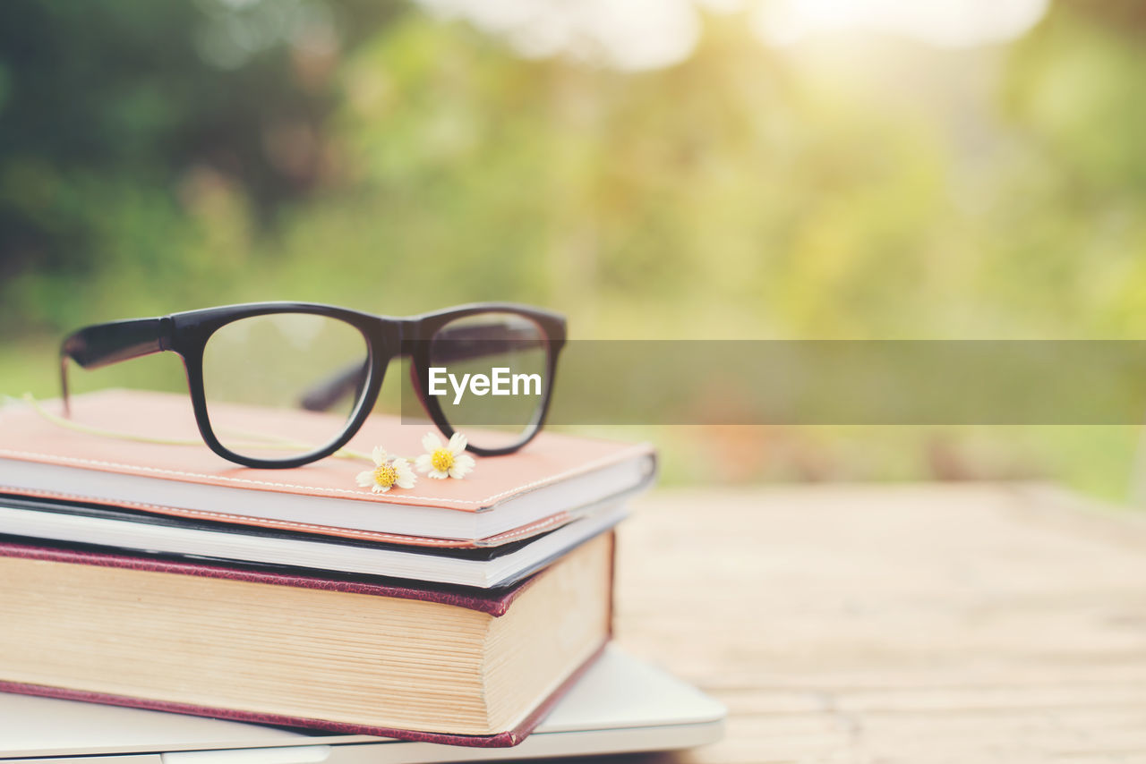 Close-up of eyeglasses on books outdoors