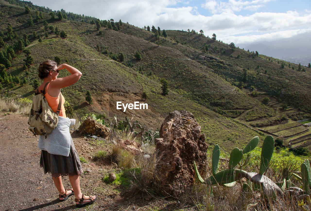 Woman looking at landscape against sky