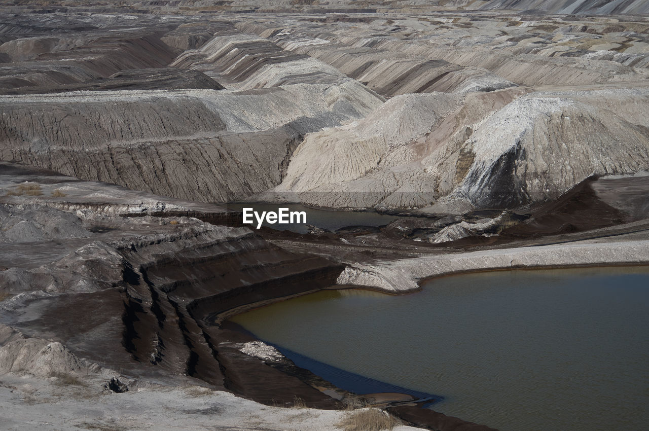 water, environment, landscape, nature, beauty in nature, scenics - nature, no people, geology, high angle view, non-urban scene, tranquility, land, day, rock, travel destinations, river, outdoors, travel, tranquil scene, mountain, wadi, mining, physical geography, mineral, rock formation, tourism