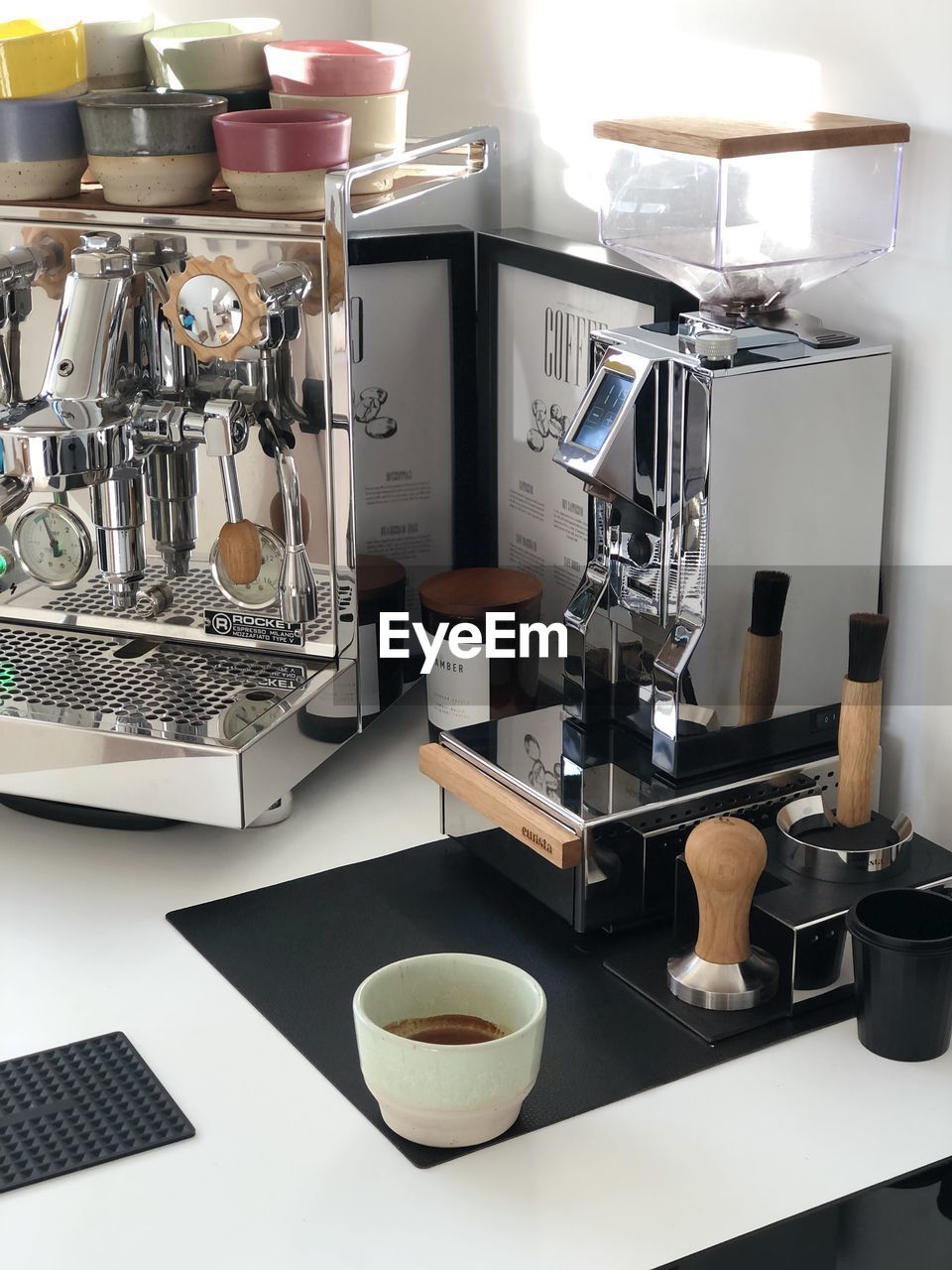 espresso machine, cup, indoors, coffee, coffeemaker, food and drink, small appliance, mug, appliance, kitchen, coffee cup, room, no people, domestic room, home, drink, domestic kitchen, kitchen utensil, household equipment, espresso maker, lifestyles, metal, home interior