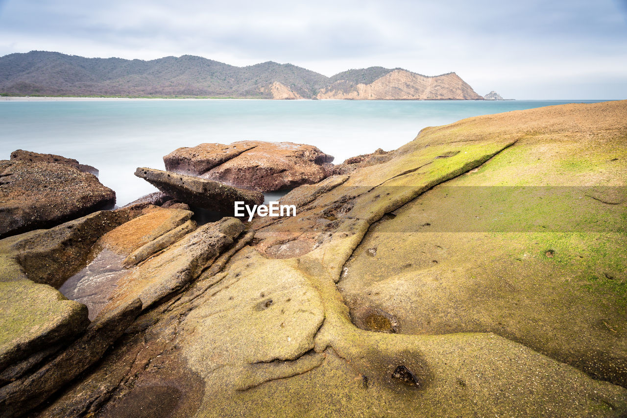 SCENIC VIEW OF ROCKS ON SHORE AGAINST SKY