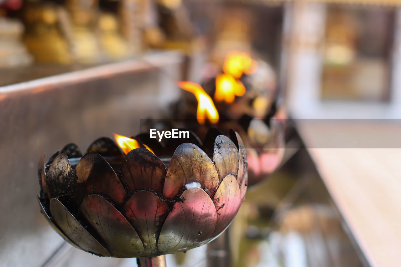 Close-up of lit candles in temple