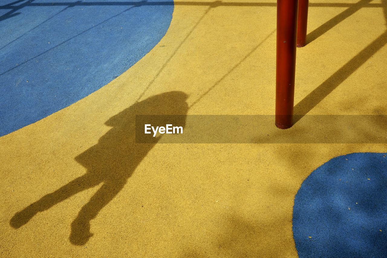 Shadow of girl swinging at playground