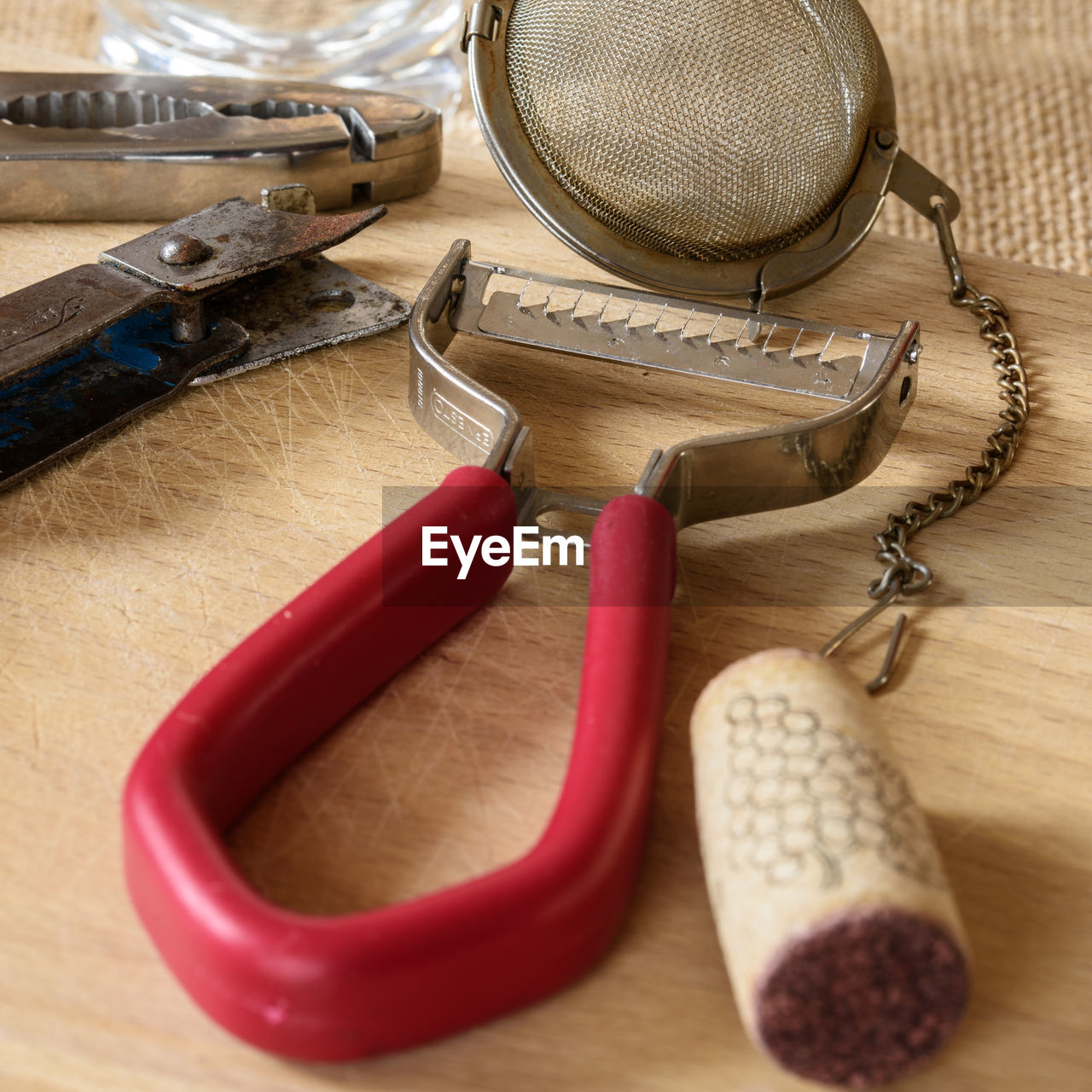 High angle view of peeler and tea strainer on wooden table