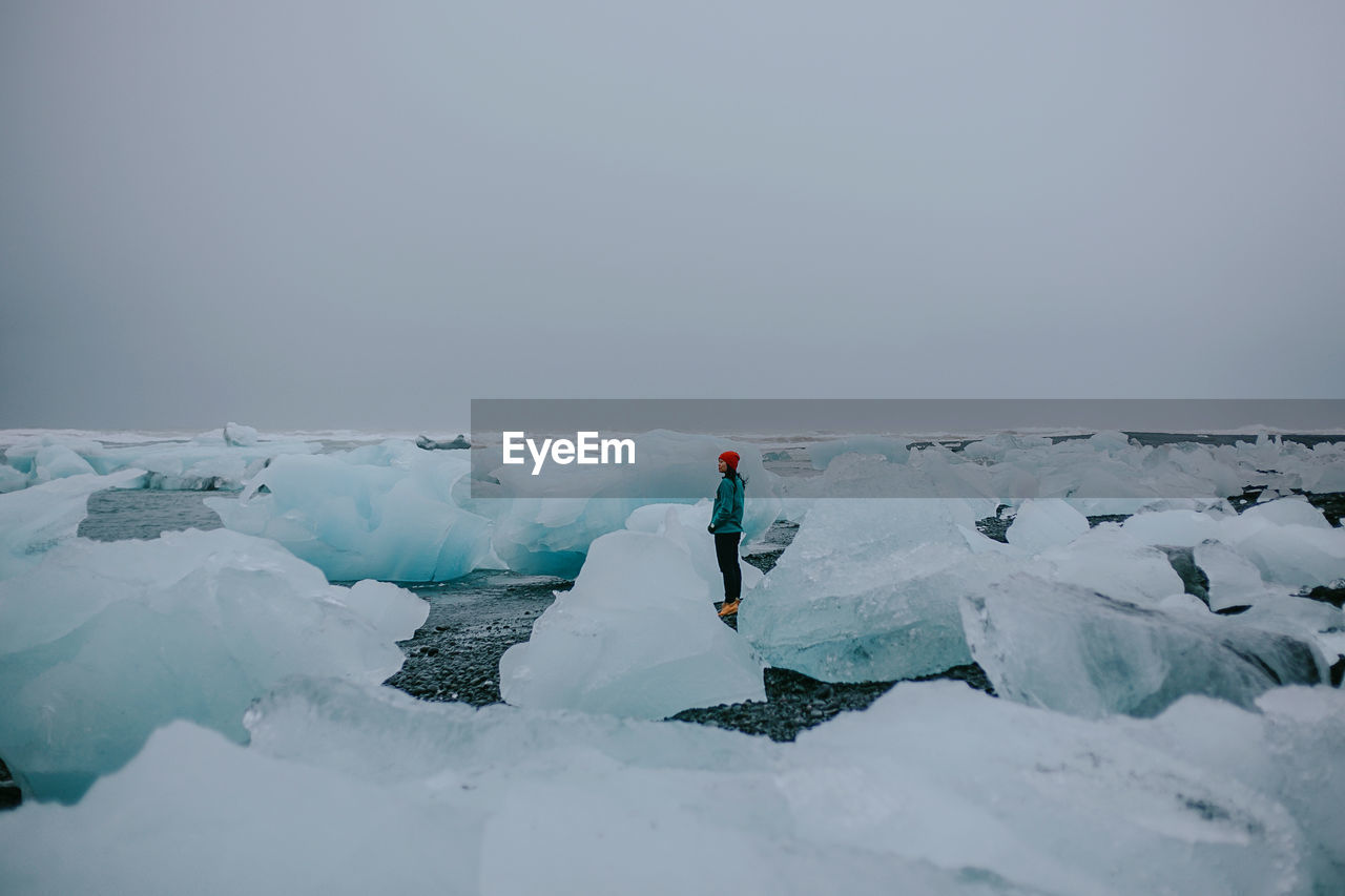 Woman standing on frozen sea