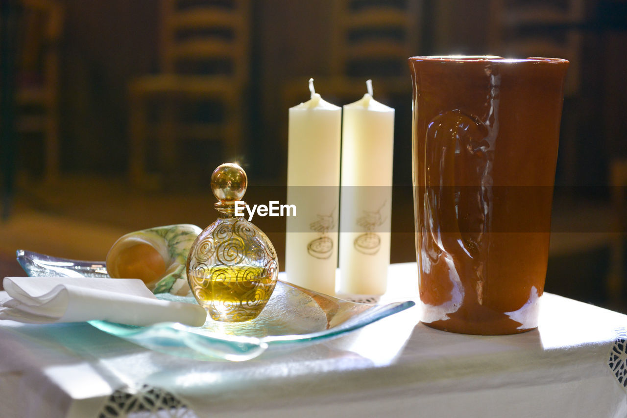 Items prepared on a table for a baptism ceremony in a church, backlit by the sun