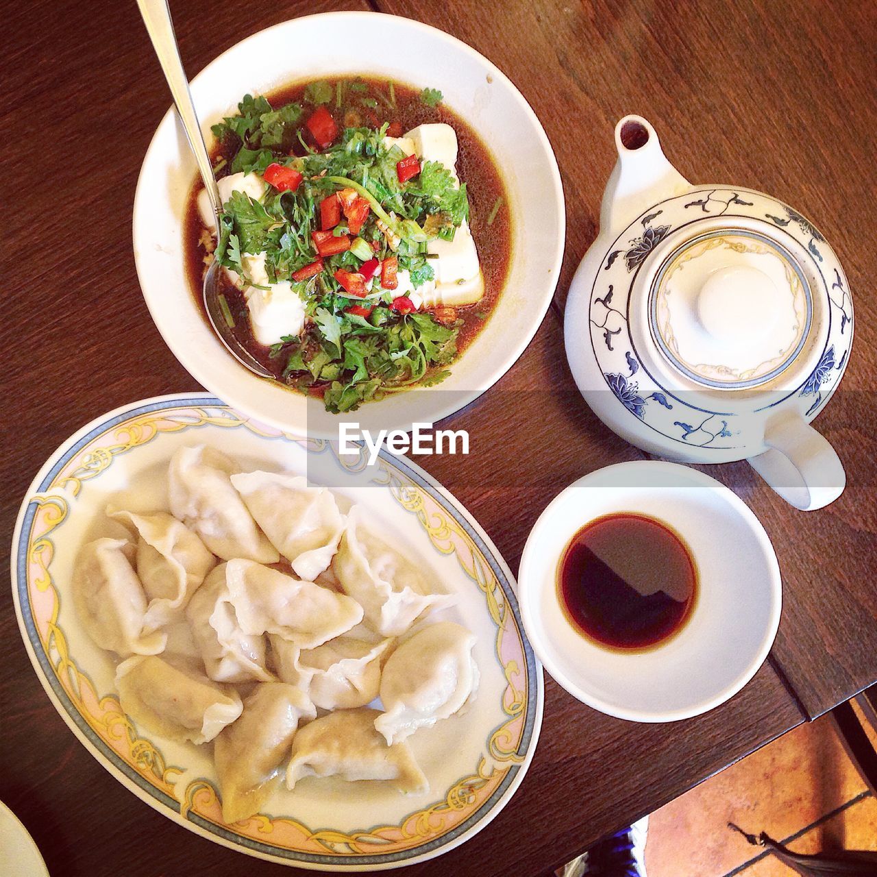 Directly above shot of chinese dumplings with soup and cup on table