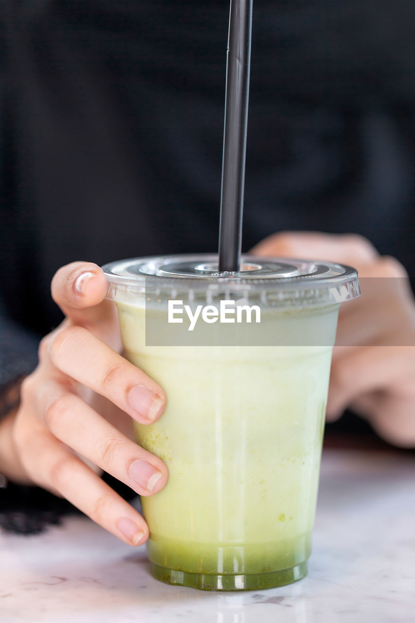 Fresh lemon and mint cocktail in female hands, closeup. healthy lifestyle.