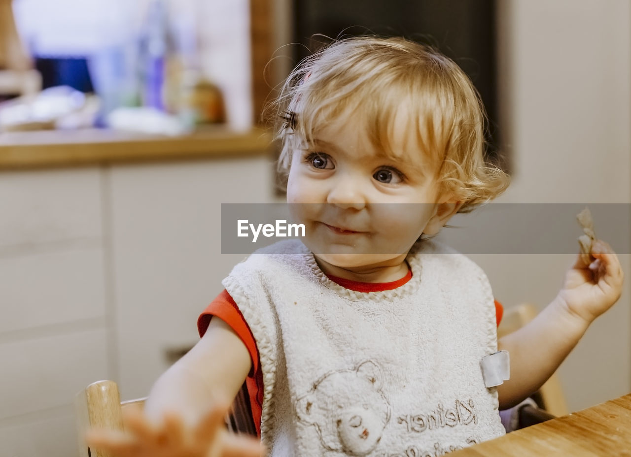 Close-up of baby girl eating food at table