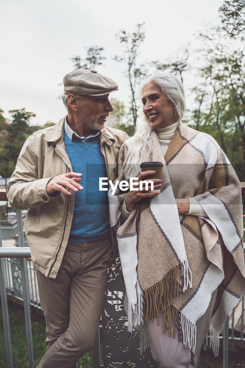 Smiling couple holding standing on footbridge