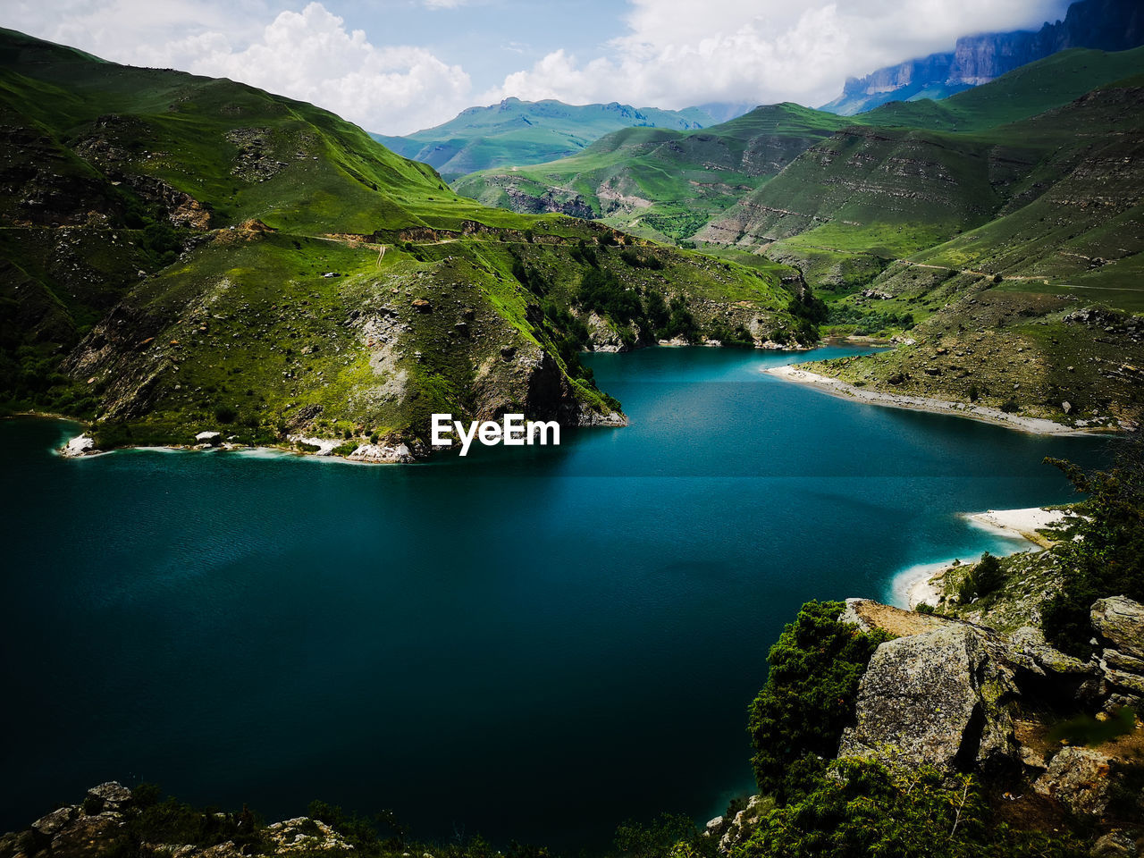 High angle view of lake and mountains against sky