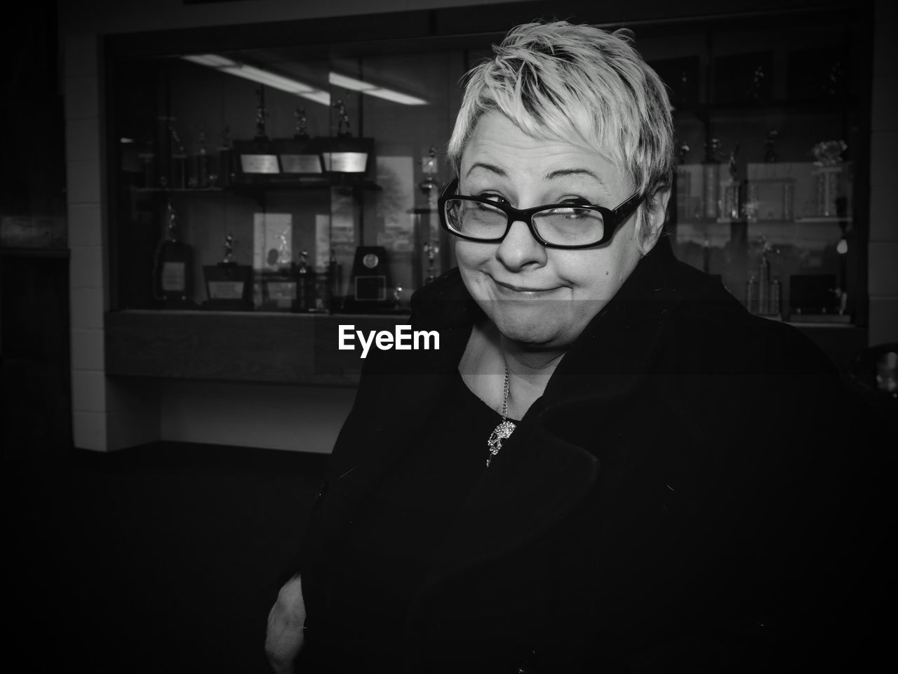 Smiling woman wearing eyeglasses looking away at office