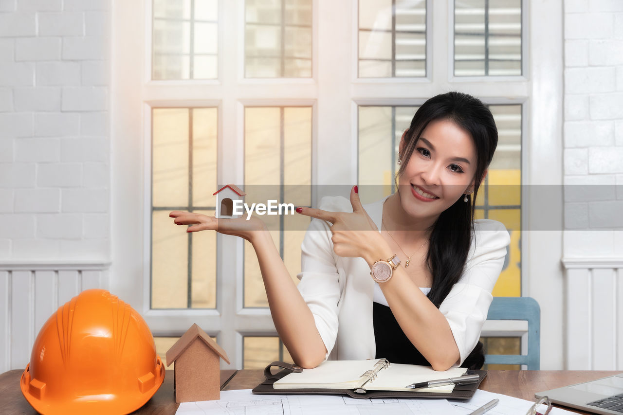 Portrait of woman gesturing on model home