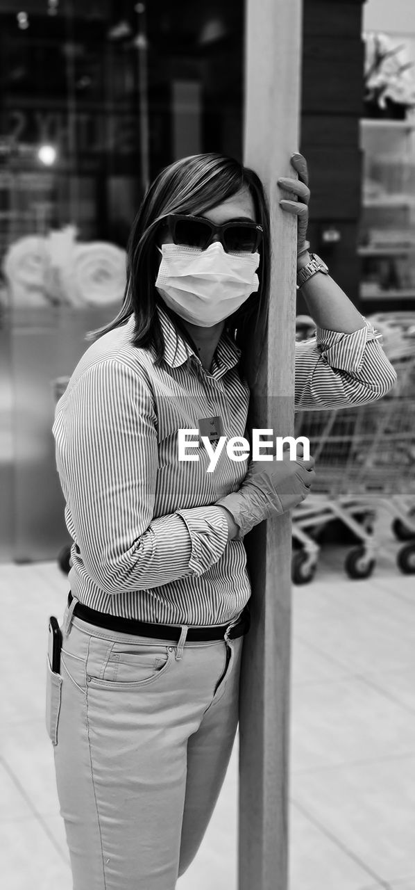 Portrait of woman wearing mask standing in shopping mall