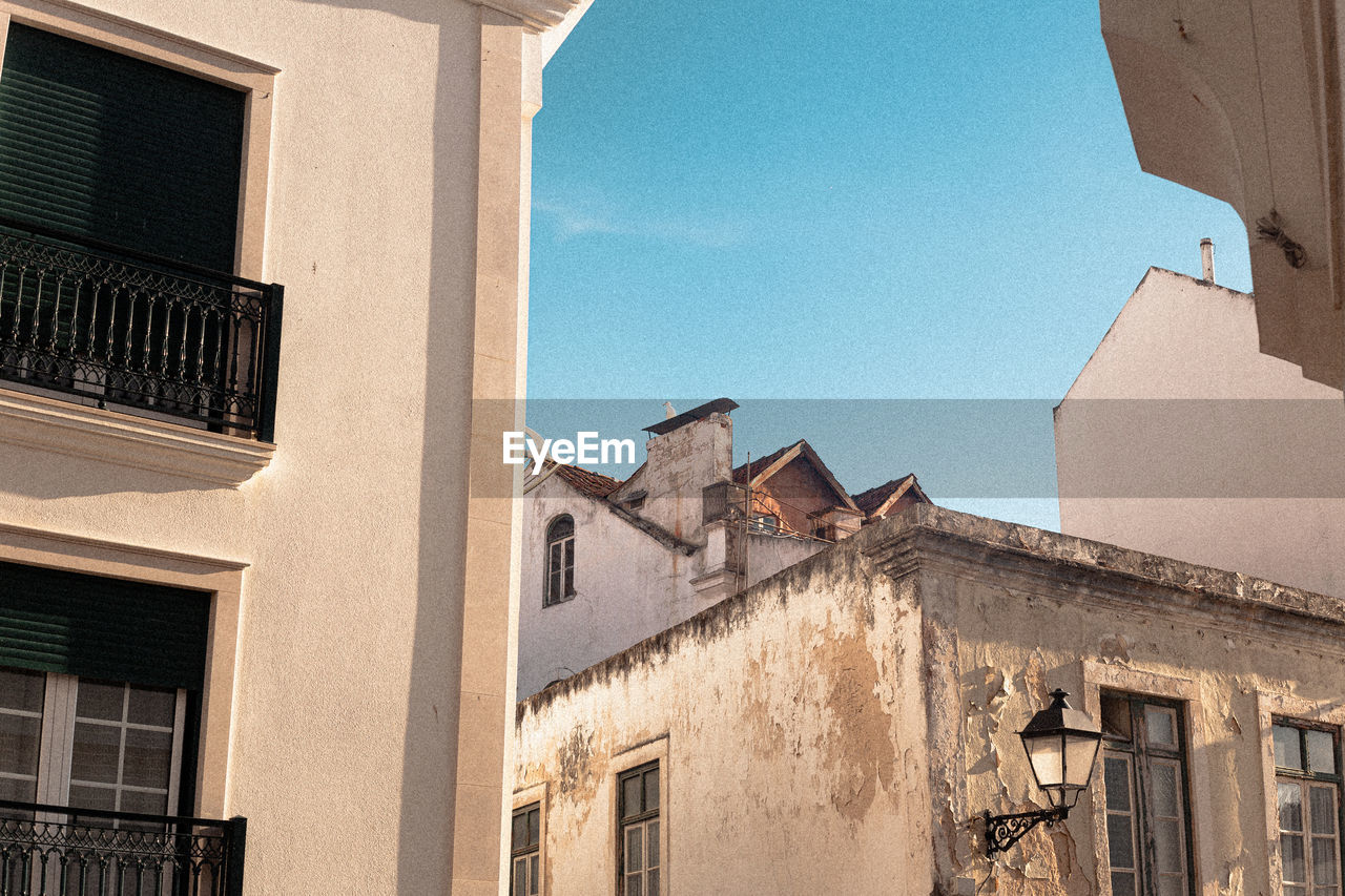 LOW ANGLE VIEW OF RESIDENTIAL BUILDINGS AGAINST BLUE SKY