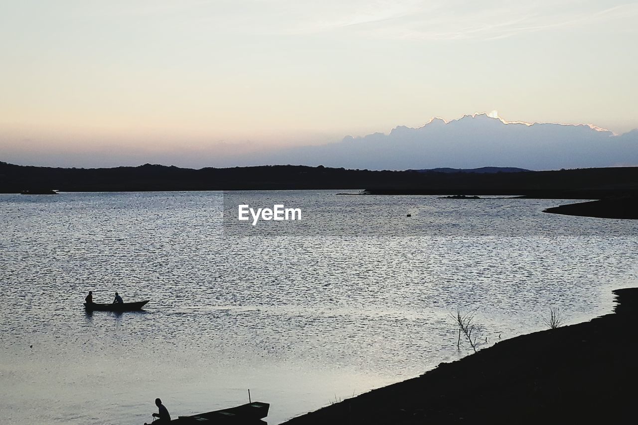 SILHOUETTE OF BOATS IN SEA AGAINST SKY