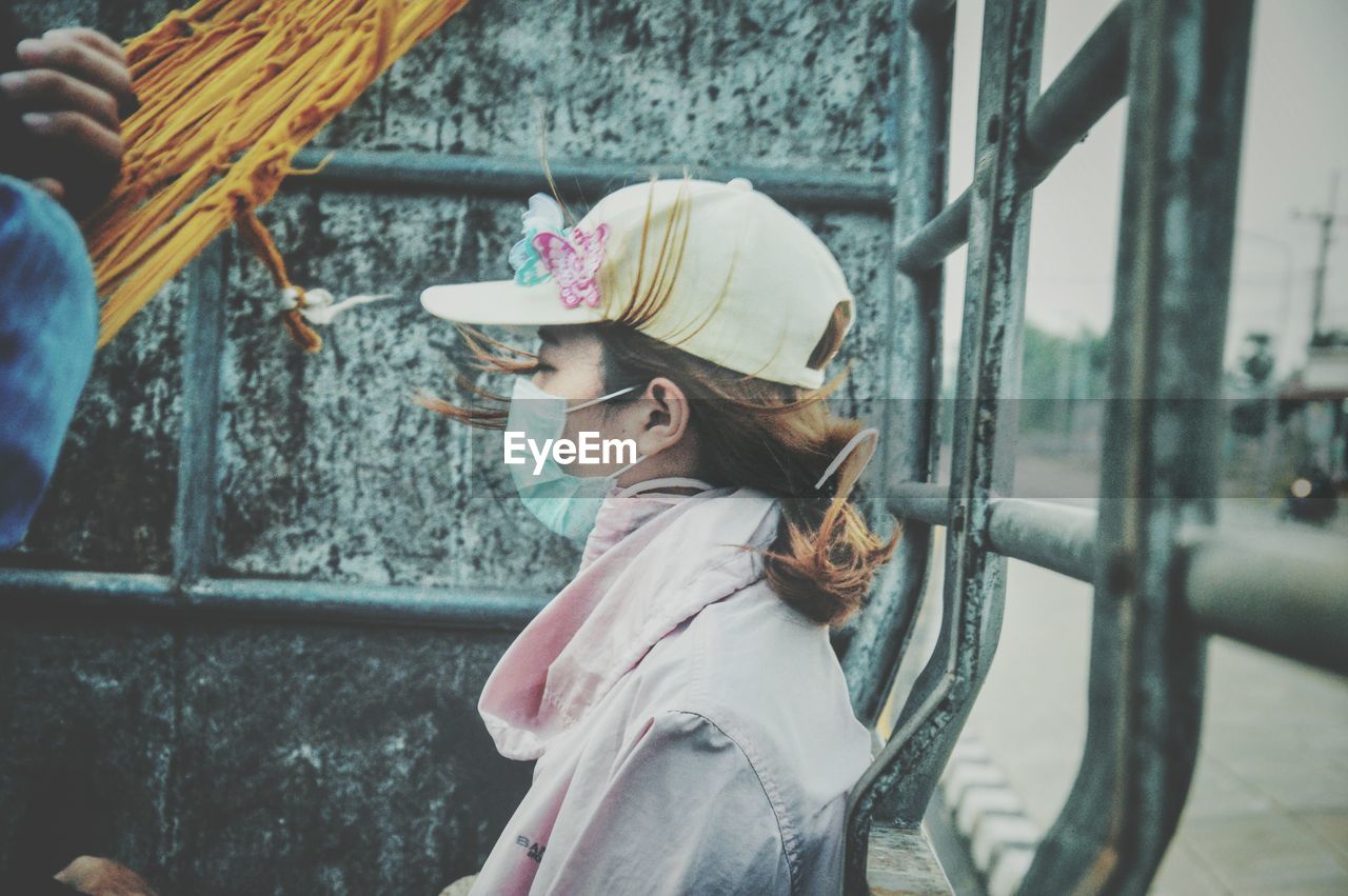 Side view of woman wearing cap