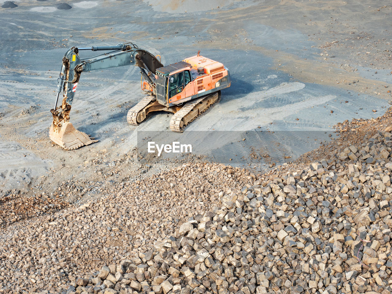 Heavy machinery in clinkstone or phonolite mining quarry. excavator with belt conveyor puts crushing