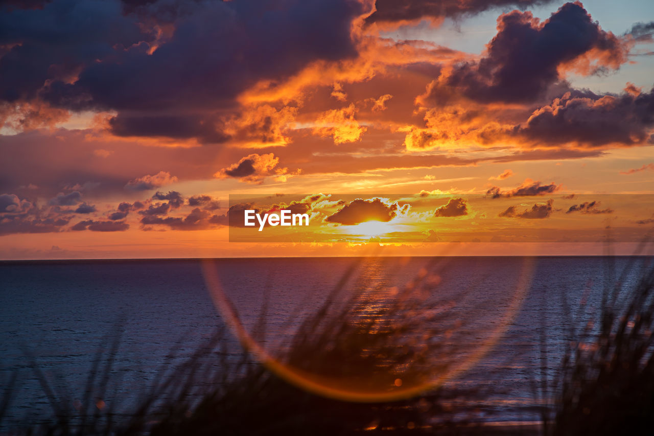 Scenic view of calm sea against sky during sunset