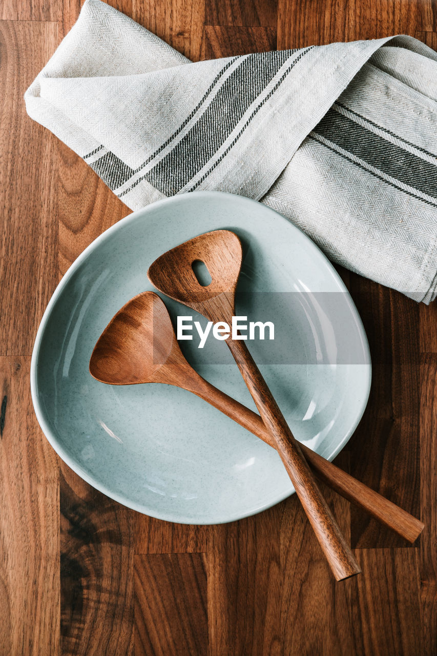 High angle view of empty plate with spoons on table