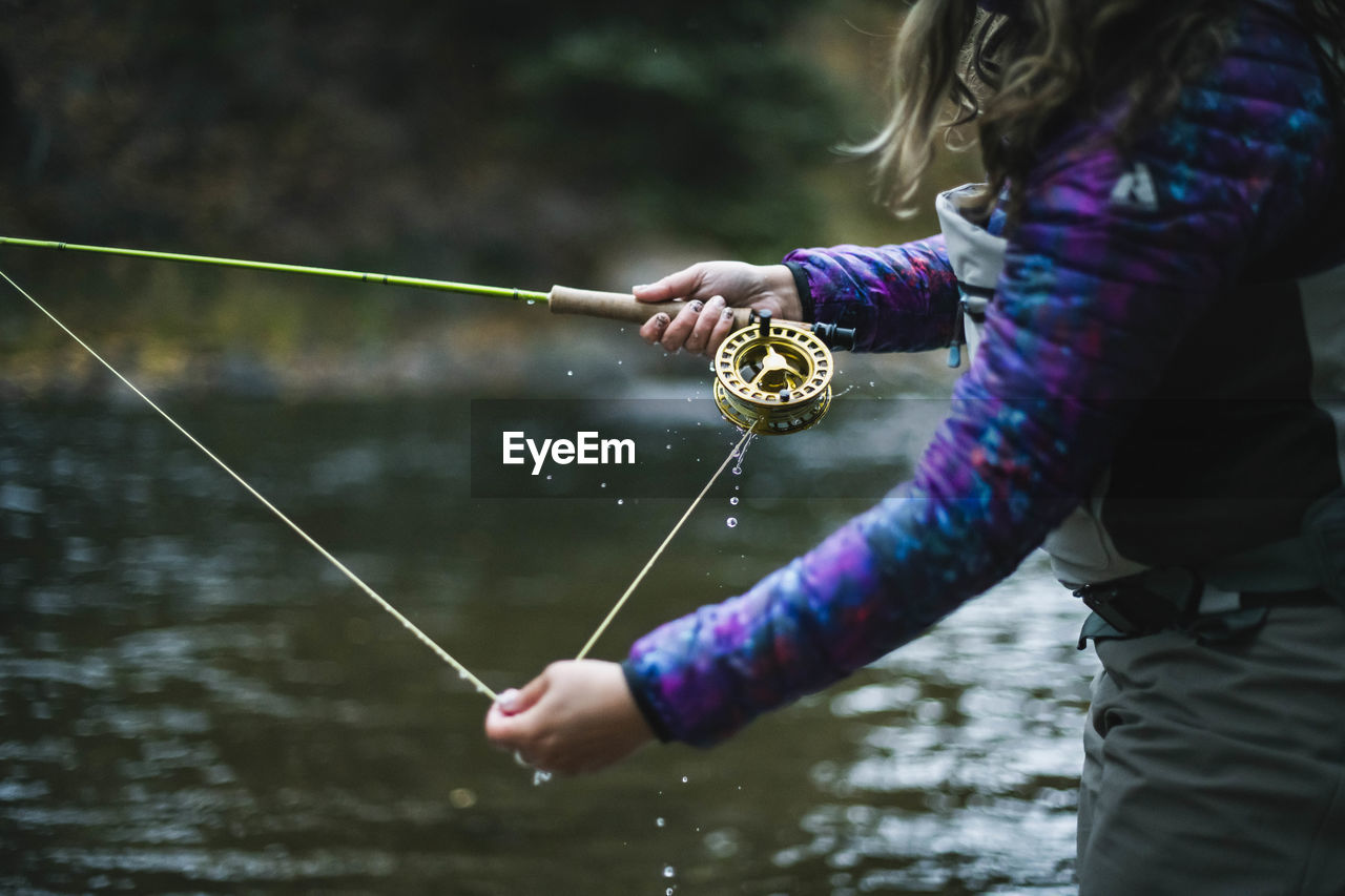 Side view of woman fly fishing at roaring fork river