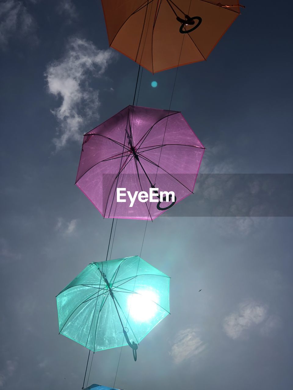 LOW ANGLE VIEW OF MULTI COLORED UMBRELLA AGAINST SKY