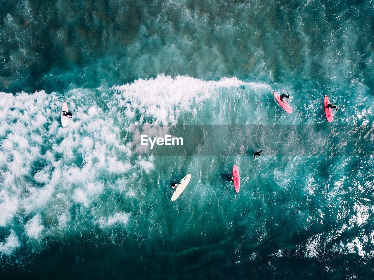 Aerial view of people surfboarding on sea