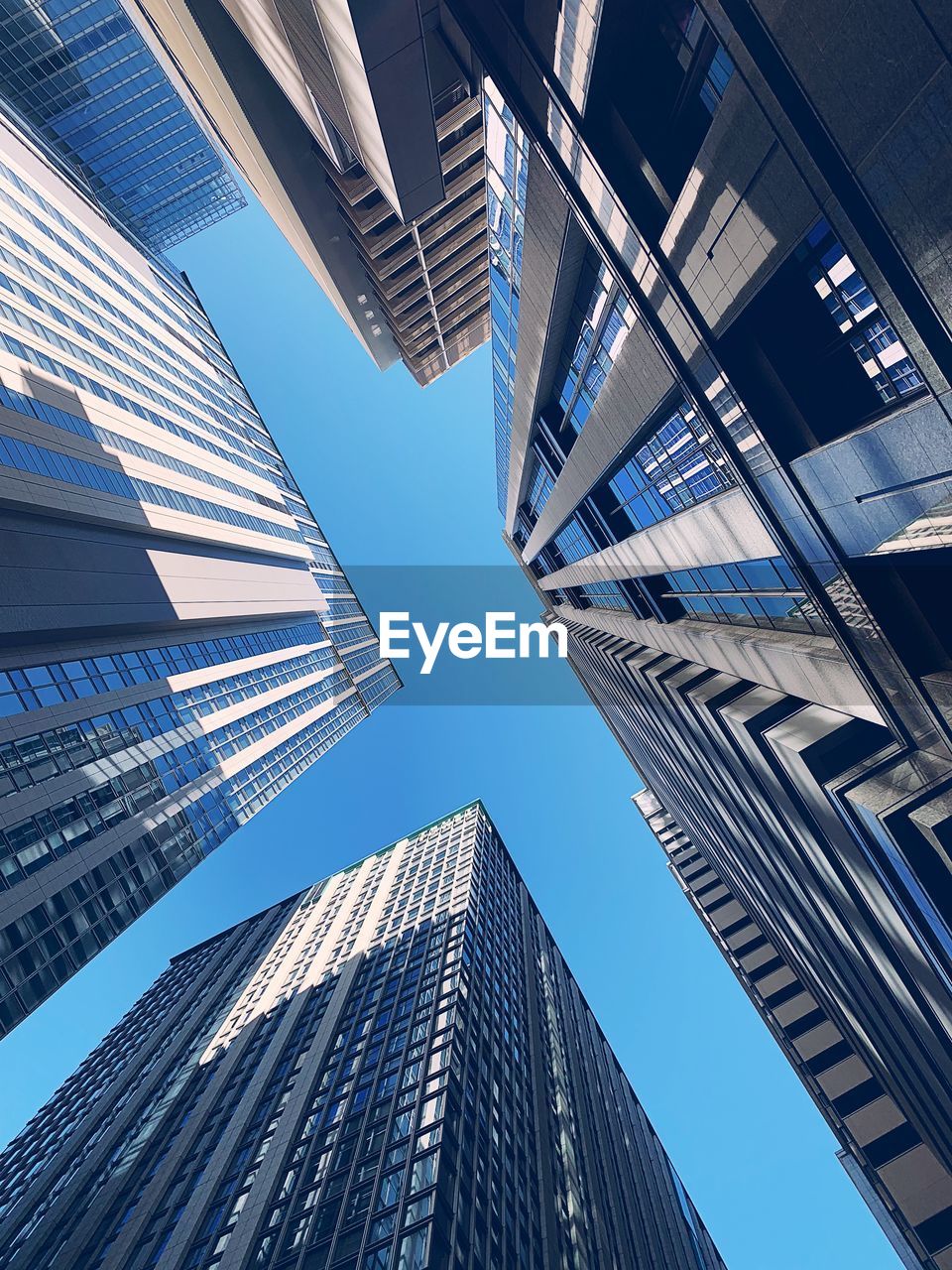 Low angle view of modern buildings against clear blue sky