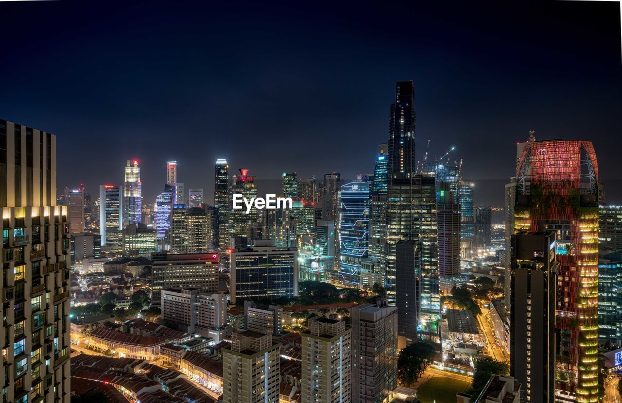 Illuminated cityscape against sky at night